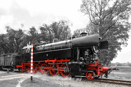 Old steam locomotive standing on rails, vintage train, general view. Isolated on white.