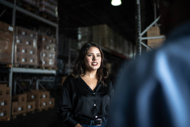 istock Young woman talking with a coworker in a warehouse 1466066537
