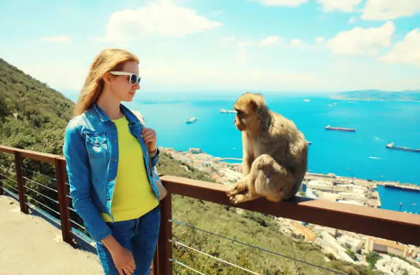 Photo of Woman tourist and macaque monkey. Gibraltar, United Kingdom