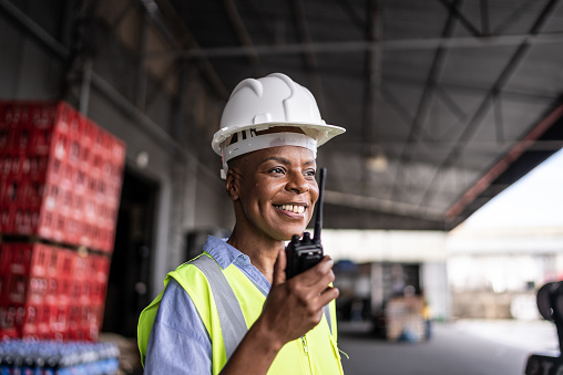 Mature woman talking on a walkie-talkie in a warehouse