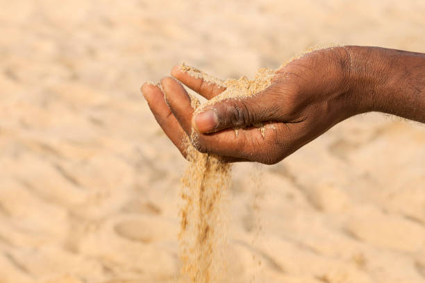 istock Climate change. Man holding  sand in his hand. Symbolic representation of desertification and drought. Photo 1466072829
