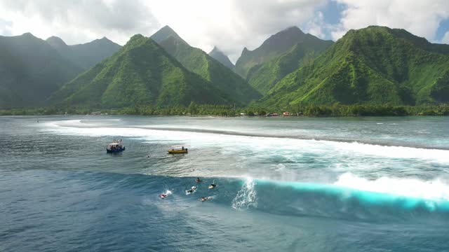 Drone Tahiti. Aerial view surf wave. Exotic tropical island, ocean lagoon, mountains in French Polynesia. Teahupoo is a famous surfing destination. Adventure travel.