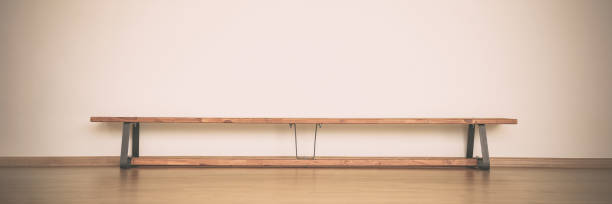 istock Empty long wooden bench stands on brown colored parquet floor 1466079147