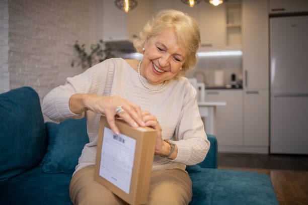istock Senior woman is holding cardboard box 1466080343