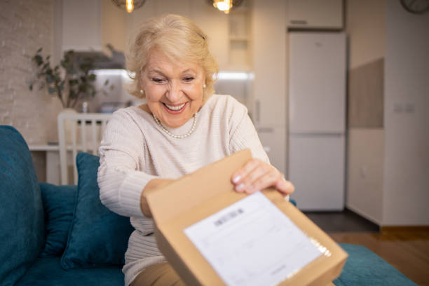 istock Senior woman is holding cardboard box 1466080349