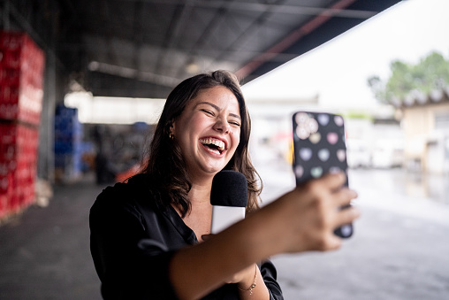 Reporter talking on the microphone in a warehouse