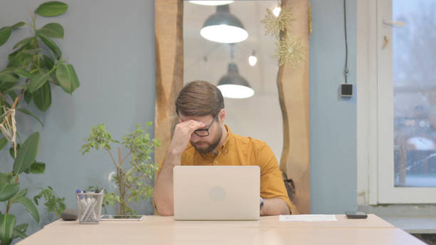 istock Young Businessman having Headache while Working on Laptop 1466098344