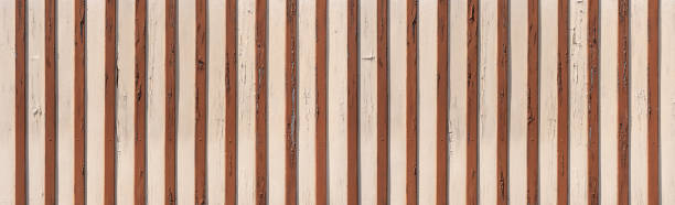 istock Bright, weathered wooden wall with applied brown wooden strips 1466098567