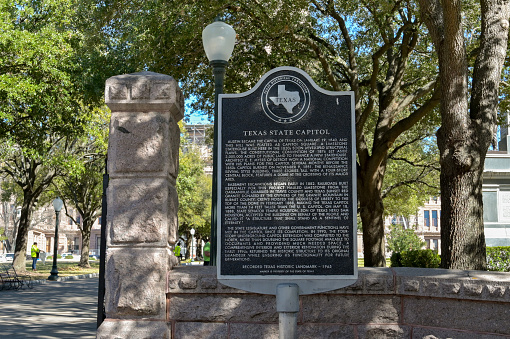 Austin, Texas, USA - February 2023: Sign at the entrance to the grounds of the State Capitol Building in the city centre. The notice provides informastion on its history.