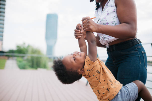 istock Mother playfully swinging her son around outside 1466100366