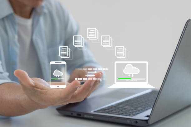 istock Man hand transfer file in screen, Smartphone and Laptop data transfer. Data transfer file between folder, Backup data, Exchange of file. Virtual document loading to another folder. Streaming download. 1466101893
