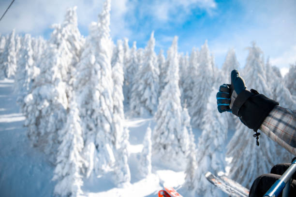 Thumb up for good ski winter season in ski resort Skier showing thumb up sitting in ski lift with astonishing view on snowy nature and ski slope. Copy space thumbs up for skiing stock pictures, royalty-free photos & images