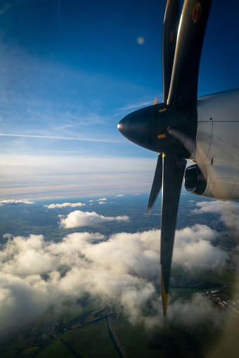 the big propeller of a propeller plane flying above the clouds