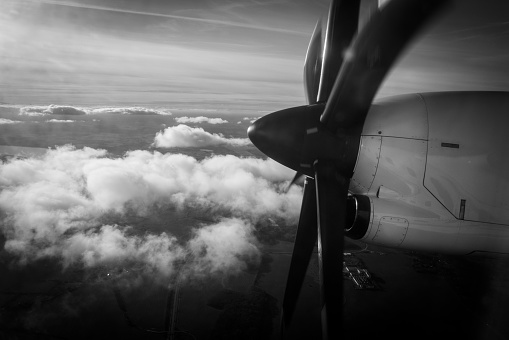 the big propeller of a propeller plane flying above the clouds