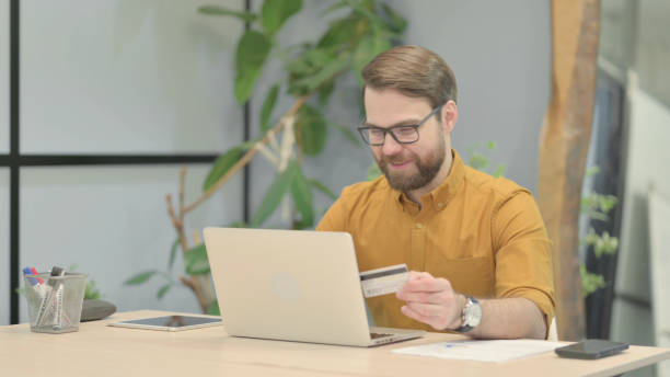 istock Excited Beard Young Man Shopping Online in Office 1466105793