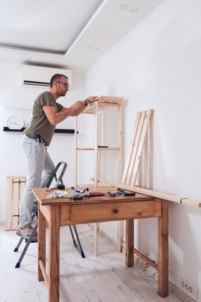 アパートで新しい木製の棚と家具を組み立てる男性。 - hobbyist ストックフォトと画像