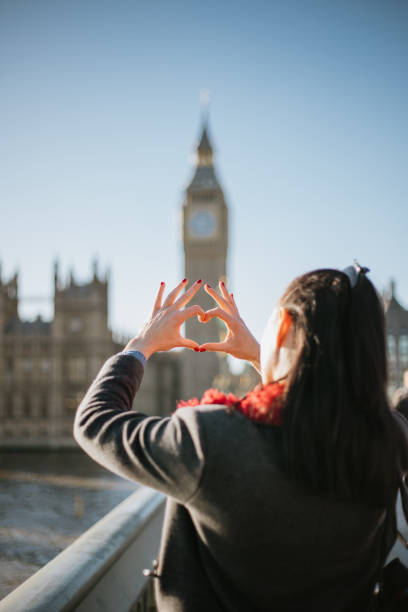 istock Beautiful woman making a heart shape with her hands on Westminster Bridge 1466115379