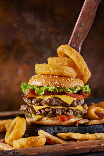 Chopped Sirloin Steak Burger with Cheese, Bacon, Lettuce, Tomatoes, Fries and Onion Rings