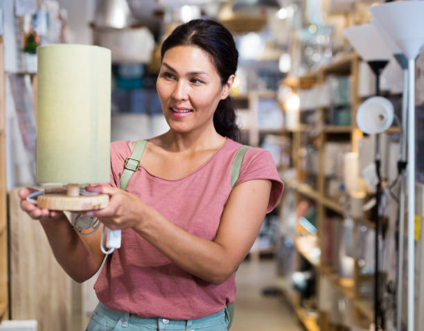 istock Woman choosing table lamp in store 1466117402