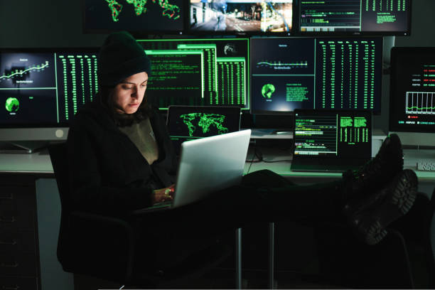 istock Informatic hacker woman typing code on laptop, at background a lot of computer screens with data. Young female programmer doing a firewall attack or phishing with online. Cyber security concept. 1466117513