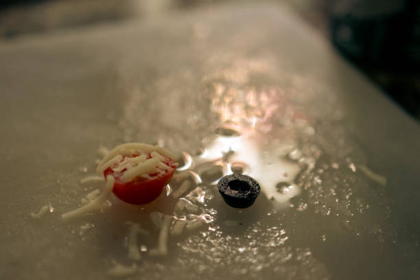 istock Chopped tomato and olive on a kitchen board with water reflection, macro photography 1466135039
