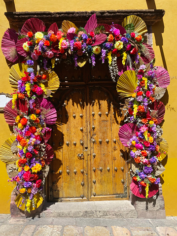 An old wooden doorway decorated with a lot of flowers
