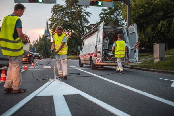 istock Road Maintenance Crew Repainting A Forward Pointing Arrow Road Sign 1466137173