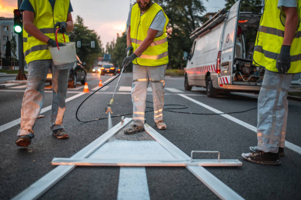 istock Maintenance Crew Spray Painting A Forward Pointing Arrow Road Sign 1466137184