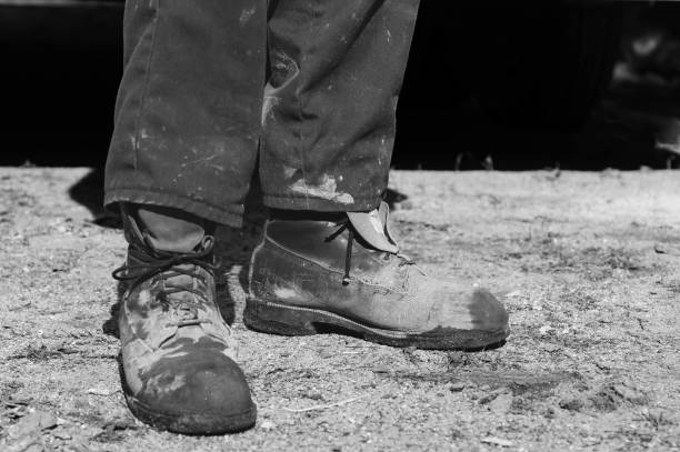 dirty cement worker boots stock photo