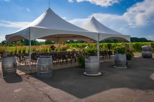 A large white tent set up for an outdoor ceremony  or banquet  or wedding on a vineyard, Quebec, Canada