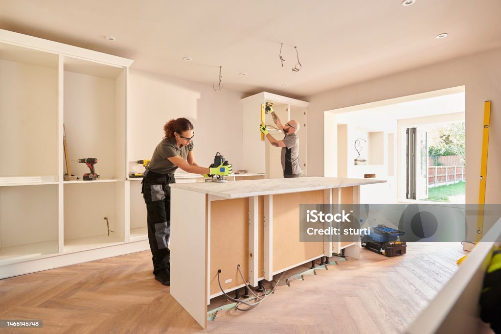 kitchen fitters installing some cabinets Renovation Stock Photo