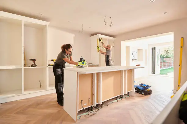 Photo of kitchen fitters installing some cabinets