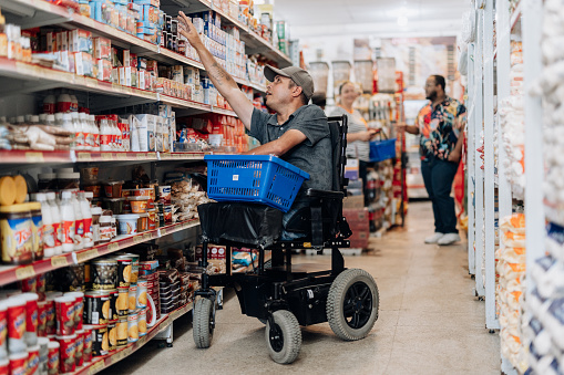 Wheelchair user trying to reach market shelf