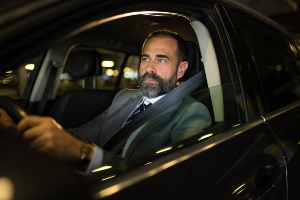 istock Mid aged man driving his car at night. 1466150353
