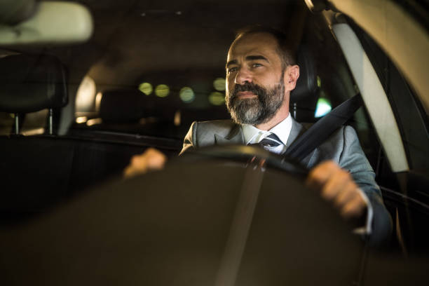 istock Mid aged man driving his car at night. 1466150438