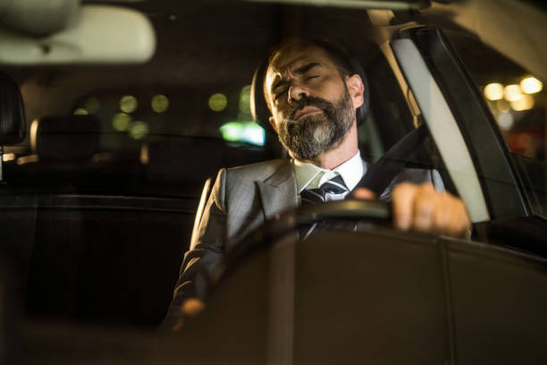 istock Mid aged man driving his car falling asleep while driving. 1466153625