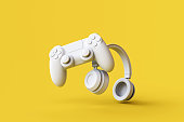 Flying gamepad and headphone on yellow background. Creative Minimal Gaming concept. 3D rendering.