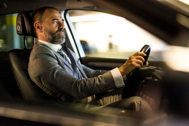 istock Mid aged man driving his car in public car garage. 1466157610