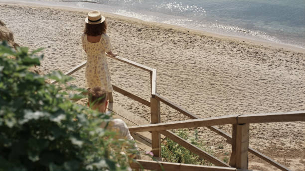 istock Couple walking down stairway on beautiful beach. Two lovers going to seashore. 1466158509