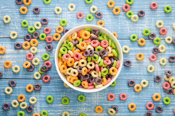 istock Colored breakfast cereals in a bowl on a blue wooden background, top view. 1466165759