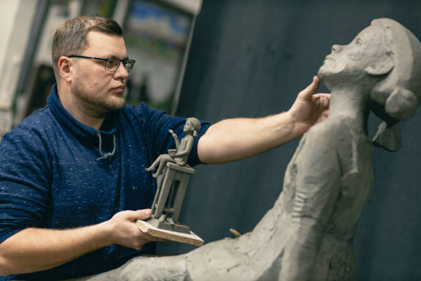 istock Man sculptor creates sculpt bust clay human woman sculpture. Statue craft creation workshop 1466169221