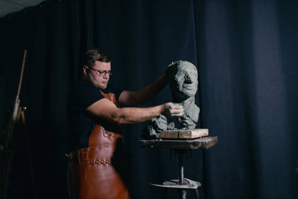 istock Man sculptor creates sculpt bust clay human woman sculpture. Statue craft creation workshop 1466169252
