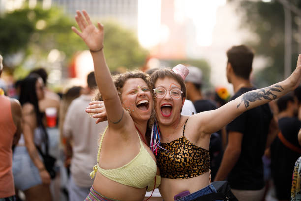 istock Women embracing each other while having fun at a carnival party 1466180198