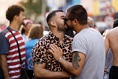 Gay couple kissing at a carnival party