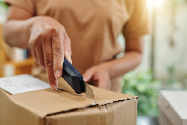 istock Woman Opening Cardboard Box 1466189013