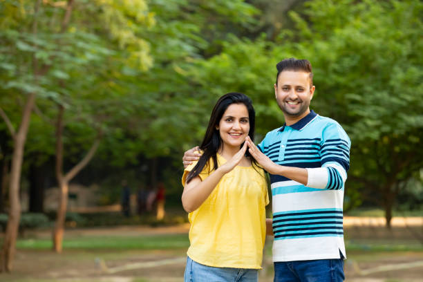 Happy Indian couple making home shape with hand. dream home concept