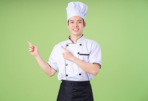 Photo of young Asian male chef on background