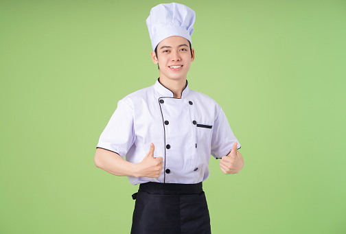 Photo of young Asian male chef on background