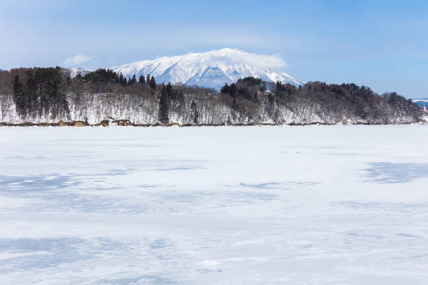 Lake Gosho in Iwate frozen over during the winter time with Mt. Iwate and surrounding mountains in the background.