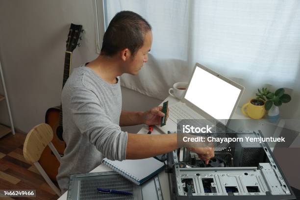 Asian Men Repairing A Computer With Learning Online At Home Stock Photo - Download Image Now